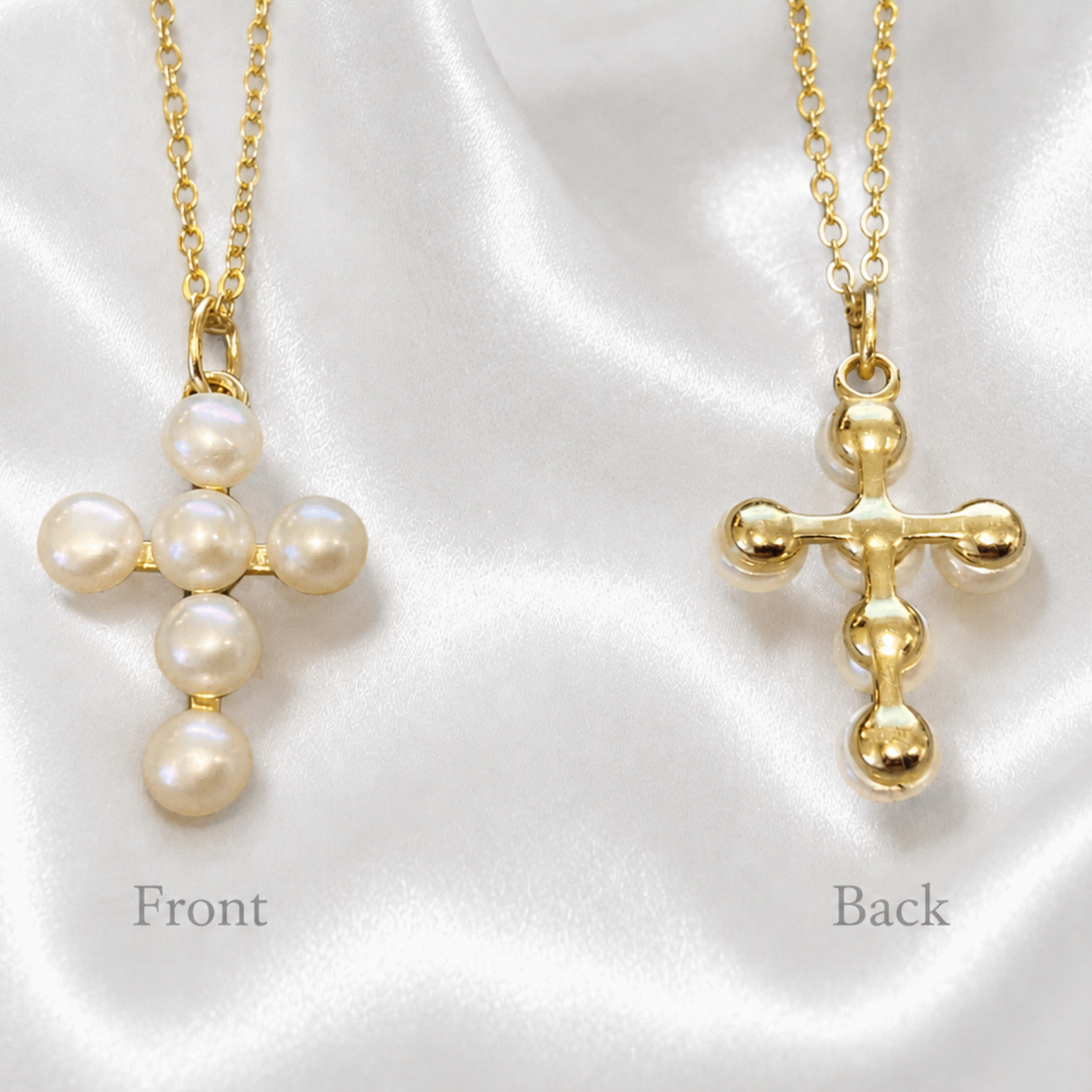 Two gold cross necklaces with pearl details, labeled 'Front' and 'Back', displayed on a white satin fabric background.
