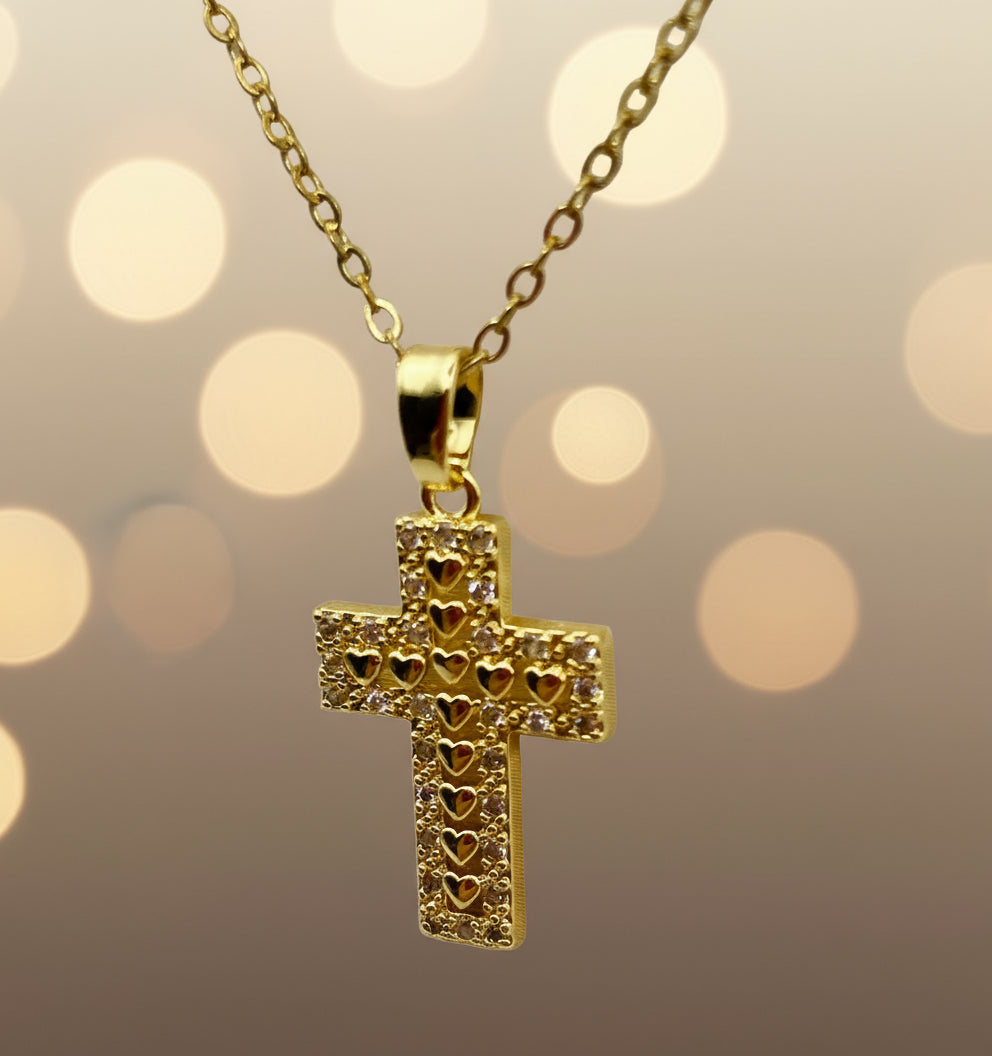 Gold cross pendant necklace on a light gray background