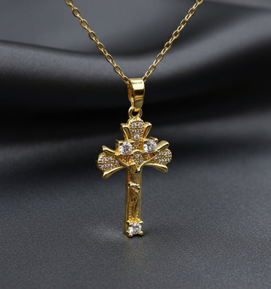 Gold cross pendant necklace on a light gray background