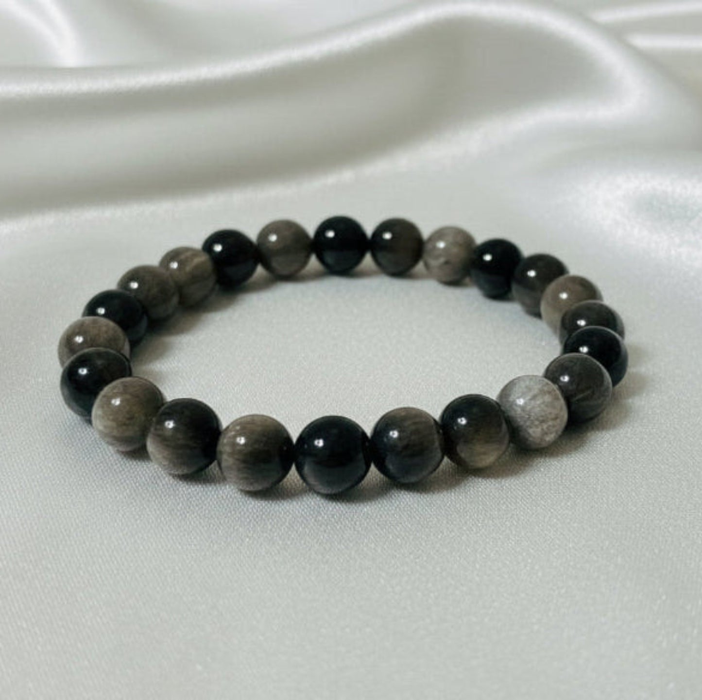 Beaded bracelet with dark stones on a white surface