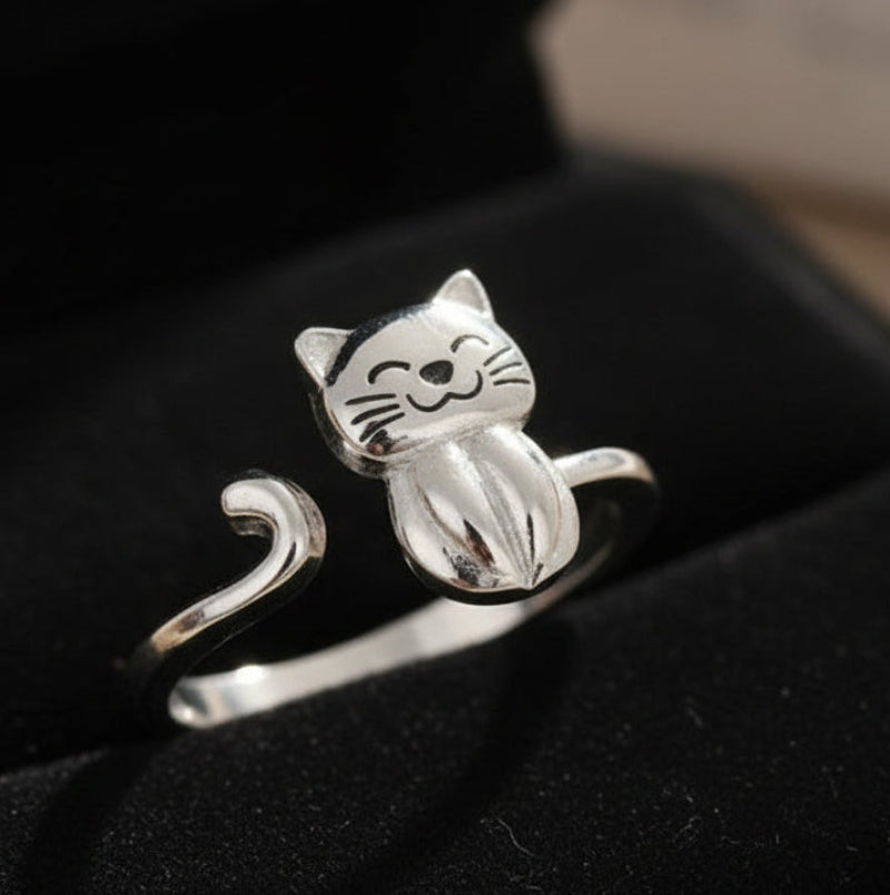 Silver cat-shaped ring on a black background