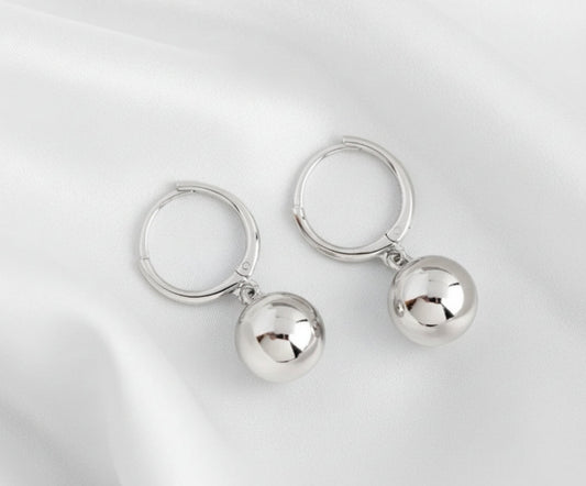 Pair of silver hoop earrings with round pendants on a white
background