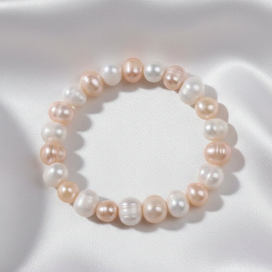 Pearl bracelet on a white surface with a white fabric background