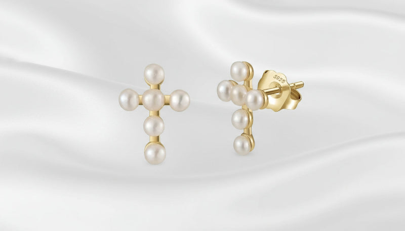 Gold earrings with pearls on a white background