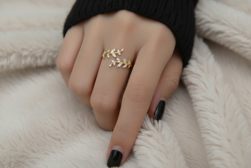 Gold leaf ring on a finger against a white background