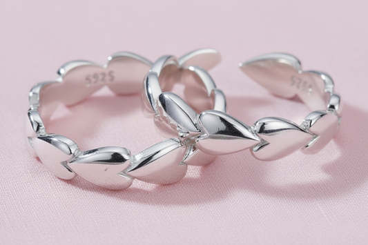 heart rings x 2 in silver on a pink surface