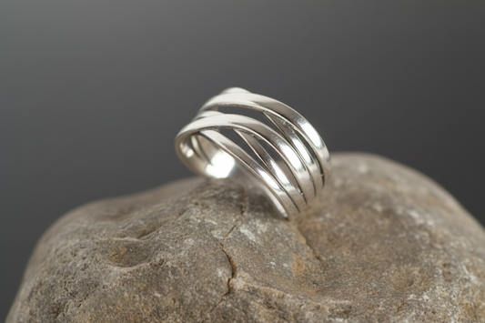 Silver ring with three intertwined bands on a white and gray background