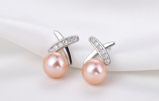 Pearl earrings with silver clasps on a white fabric background
