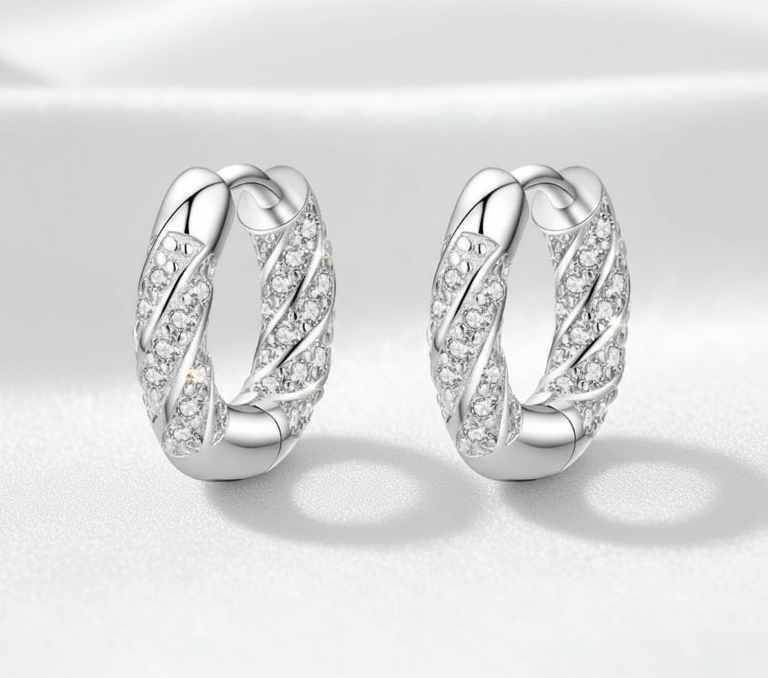 Enhanced Twisted Huggie Earrings on White Surface