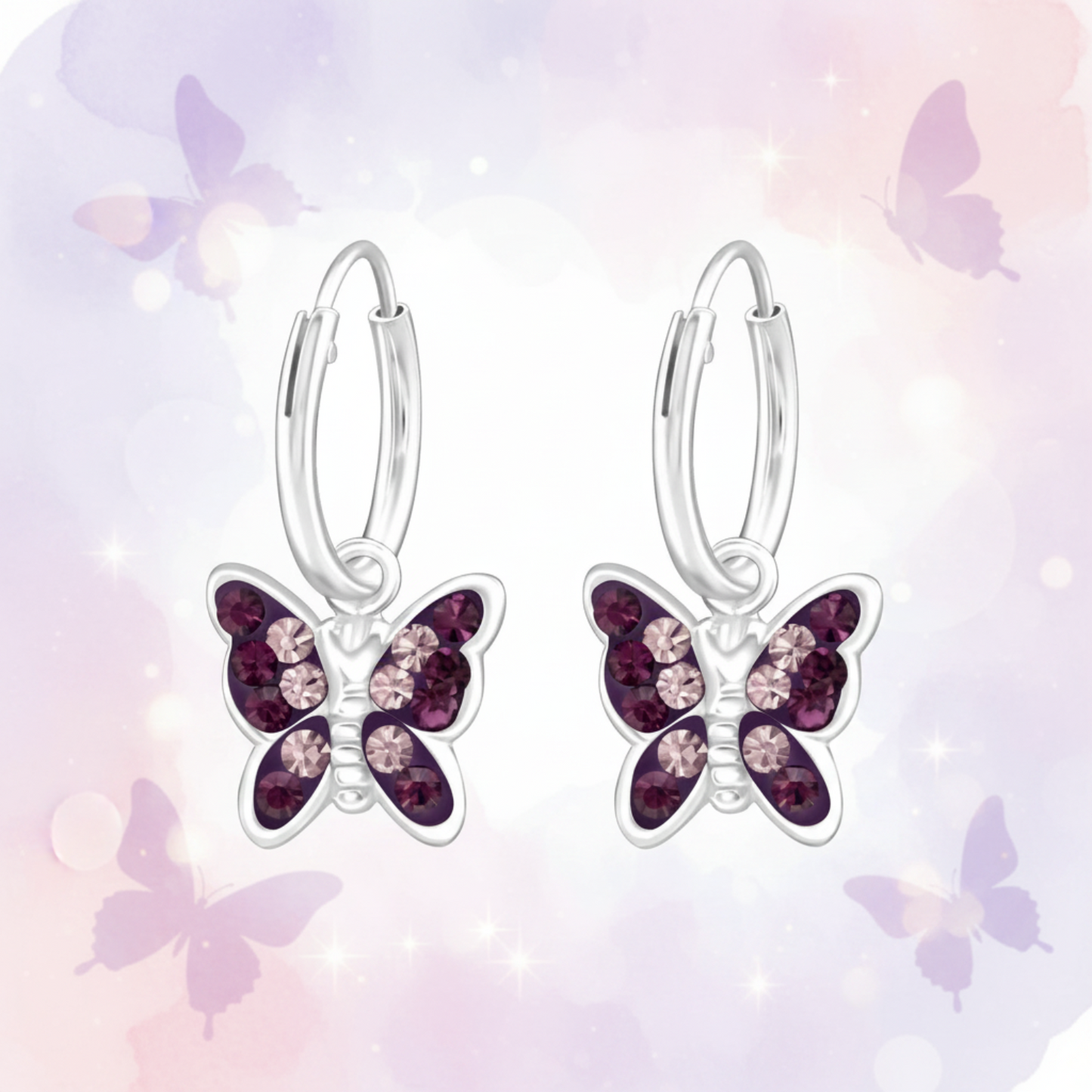A pair of silver hoop earrings with butterfly charms, featuring dark purple and light pink rhinestones, set against a soft pastel background with butterfly silhouettes.