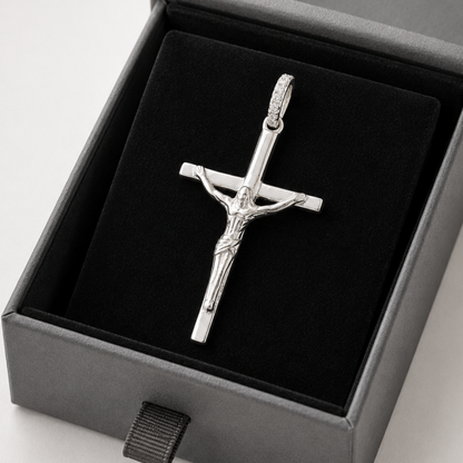 Silver crucifix pendant in a gray box on a black background