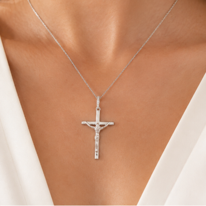 Silver cross necklace on a model wearing a white top