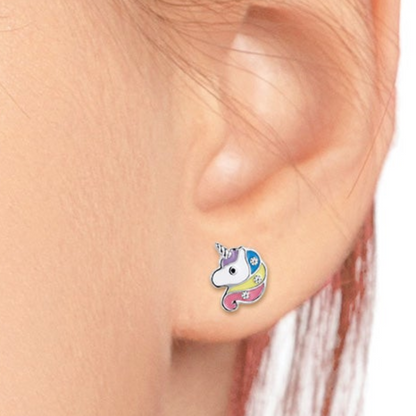 A close-up of a person's ear wearing a small colorful unicorn stud earring. The earring features a white unicorn face with a blue horn and pastel blue, pink, yellow, and purple details.