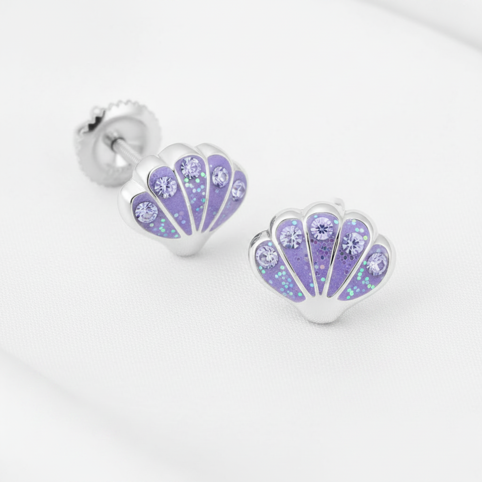 Silver-plated shell-shaped stud earrings with a lavender purple floral pattern and rhinestones, shown on a white textured background with a 'Rhodium PLATED' text overlay and a circular inset demonstrating the rhinestone setting.