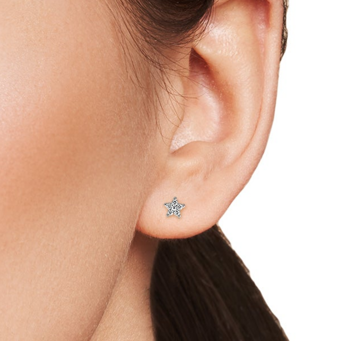 Close-up of a woman's face with a focus on her earrings.