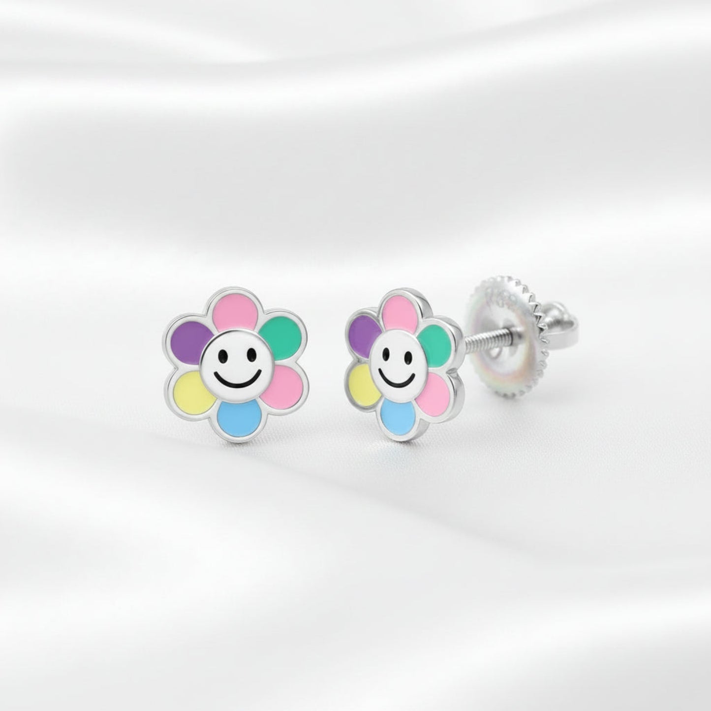 Smiley face flower stud earrings in rhodium-plated silver with multicolor enamel petals, shown on a white background with a back view and an inset demonstrating the screw-back fastening.