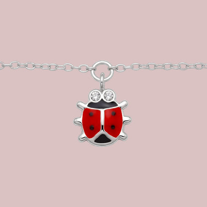 A sterling silver ladybug pendant necklace with red and black enamel wings and two clear rhinestone eyes, shown on a white background.