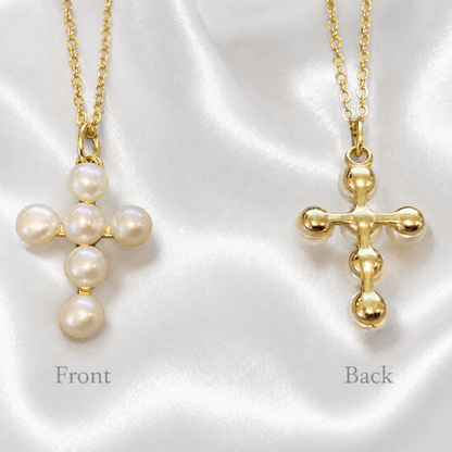 Two gold cross necklaces with pearl details, labeled 'Front' and 'Back', displayed on a white satin fabric background.