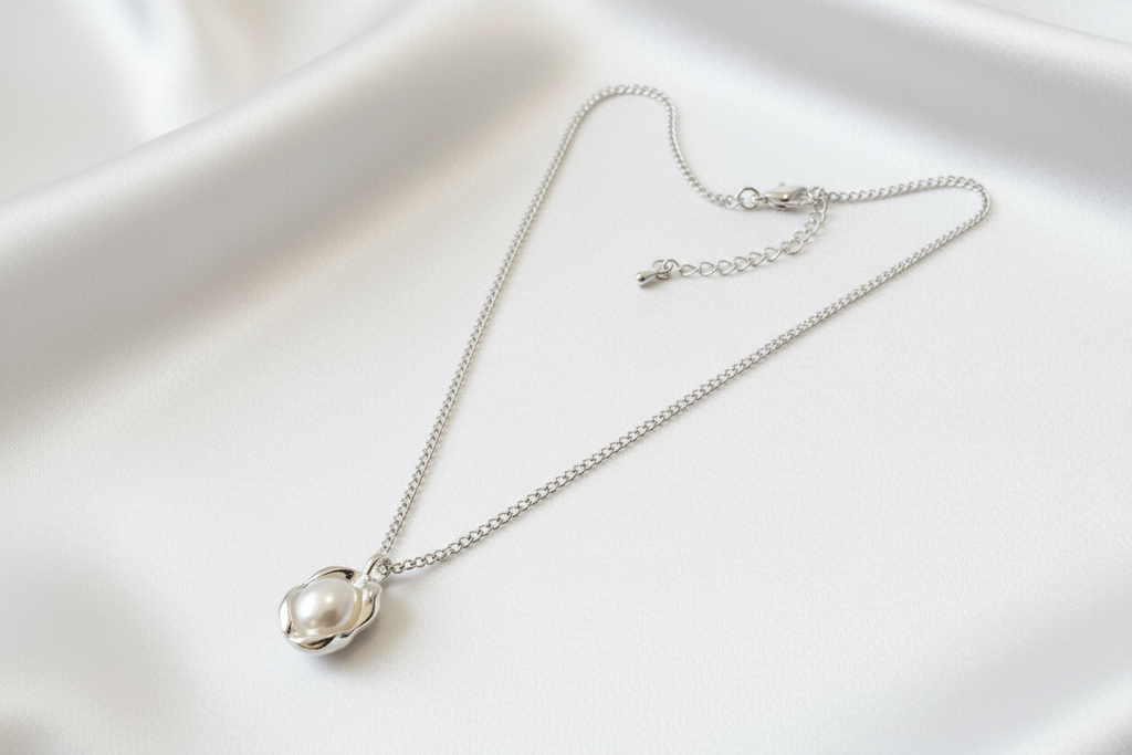 Silver necklace with a pearl pendant on a white background