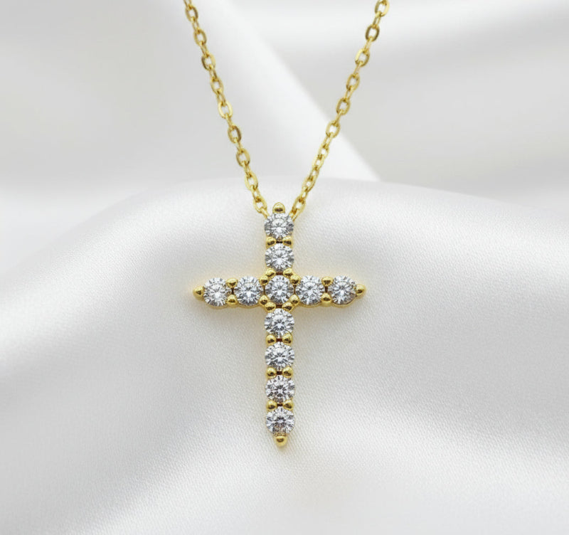 Gold cross pendant necklace with diamonds on a white background