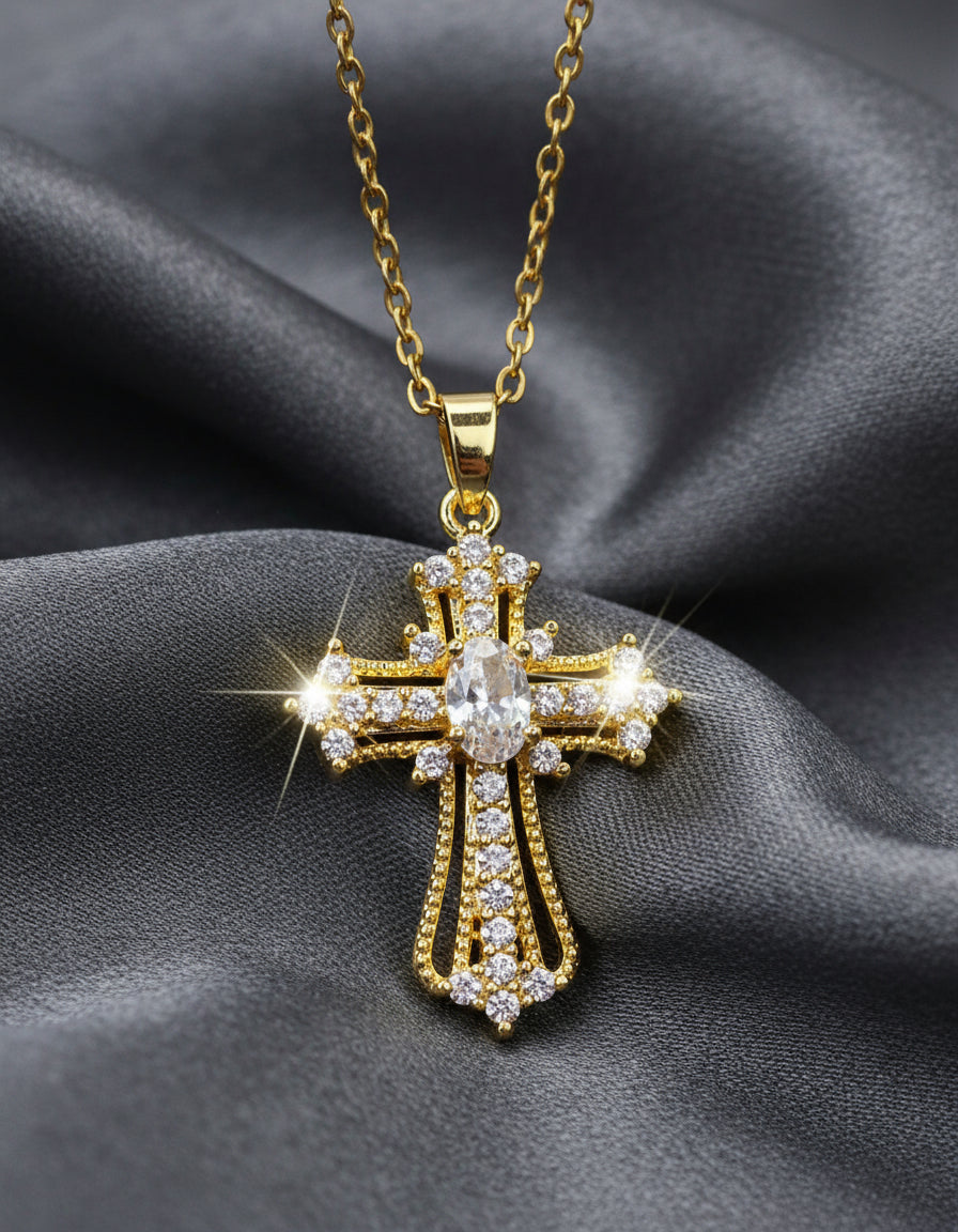 Gold cross pendant with clear stones on a light gray background