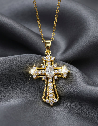 Gold cross pendant with clear stones on a light gray background