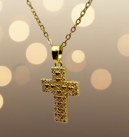 Gold cross pendant necklace on a light gray background