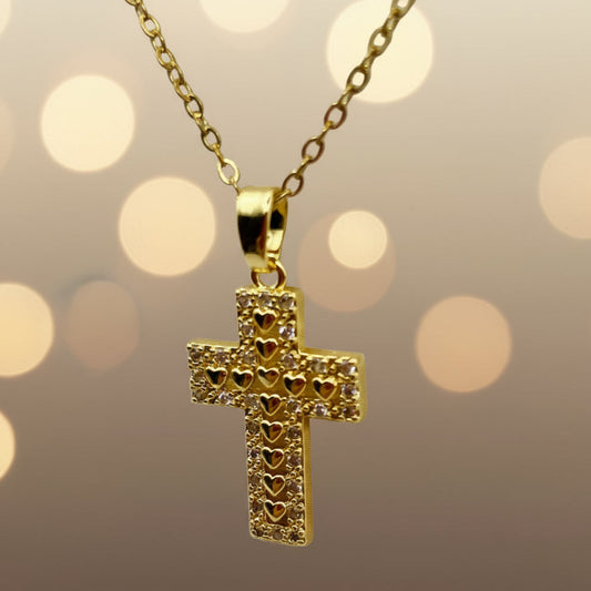 Gold cross pendant necklace on a light gray background