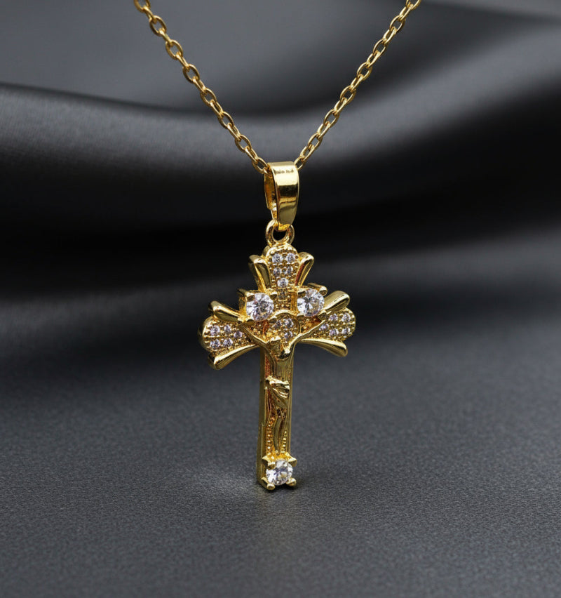 Gold cross pendant necklace on a light gray background