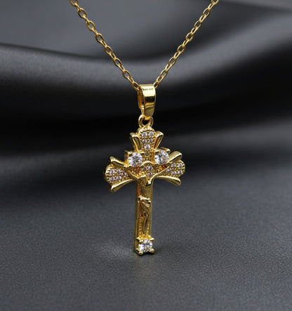 Gold cross pendant necklace on a light gray background