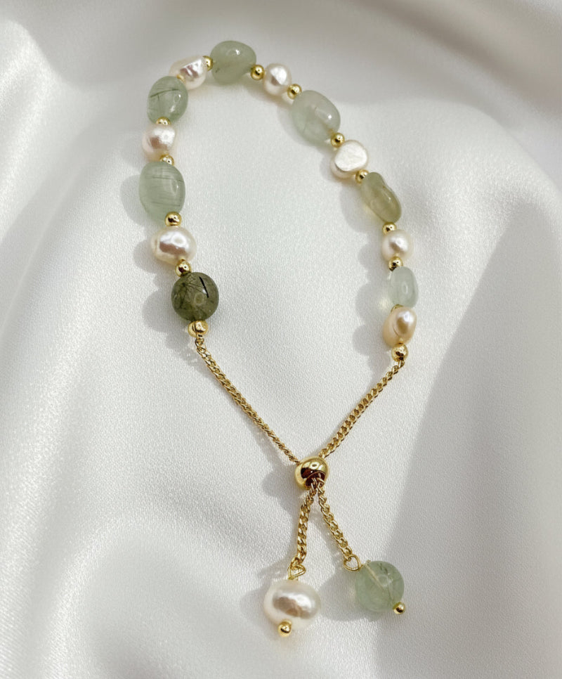 Necklace with green and gold beads on a white background