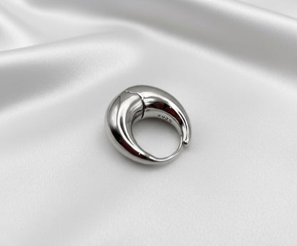 Silver ring on a white satin background