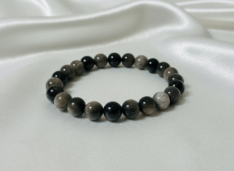 Beaded bracelet with dark stones on a white surface