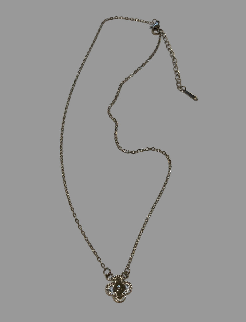 Silver necklace with a floral pendant on a light gray surface