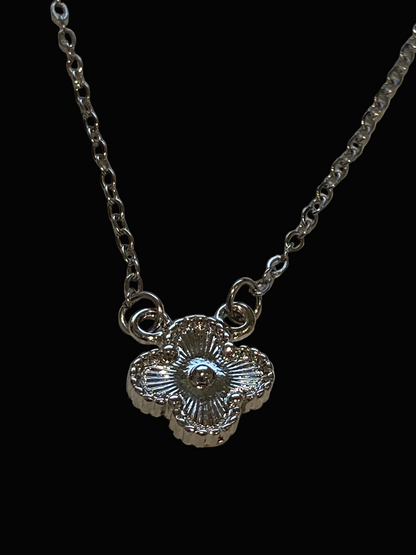 Silver necklace with a quatrefoil 
pendant on a black background