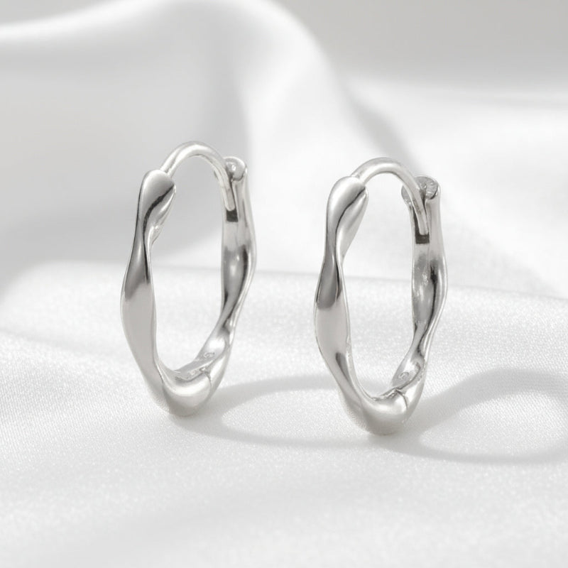 Pair of silver hoop earrings on a white background