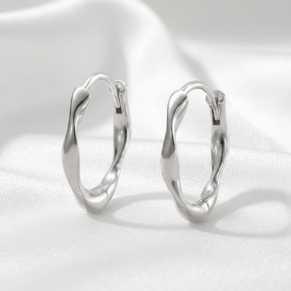 Pair of silver hoop earrings on a white background