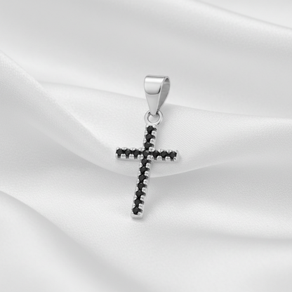 A sterling silver cross pendant featuring a row of small black gemstones along its edges, set against a plain white background.