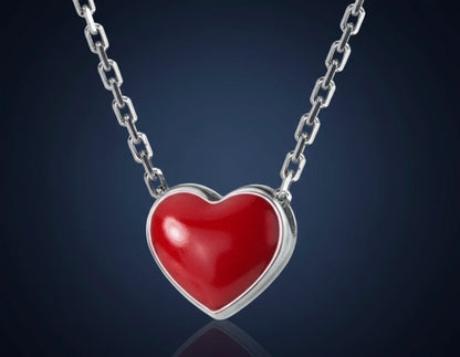 Red heart-shaped pendant on a silver chain against a white background