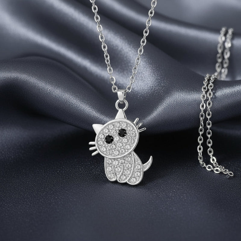 Silver cat-shaped pendant necklace with black and clear stones on a white background