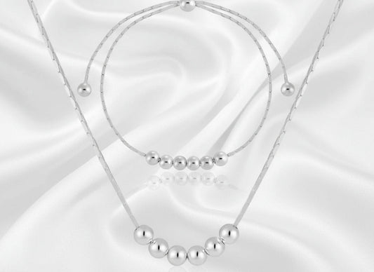 silver necklace and matching bracelet with beads on a white background