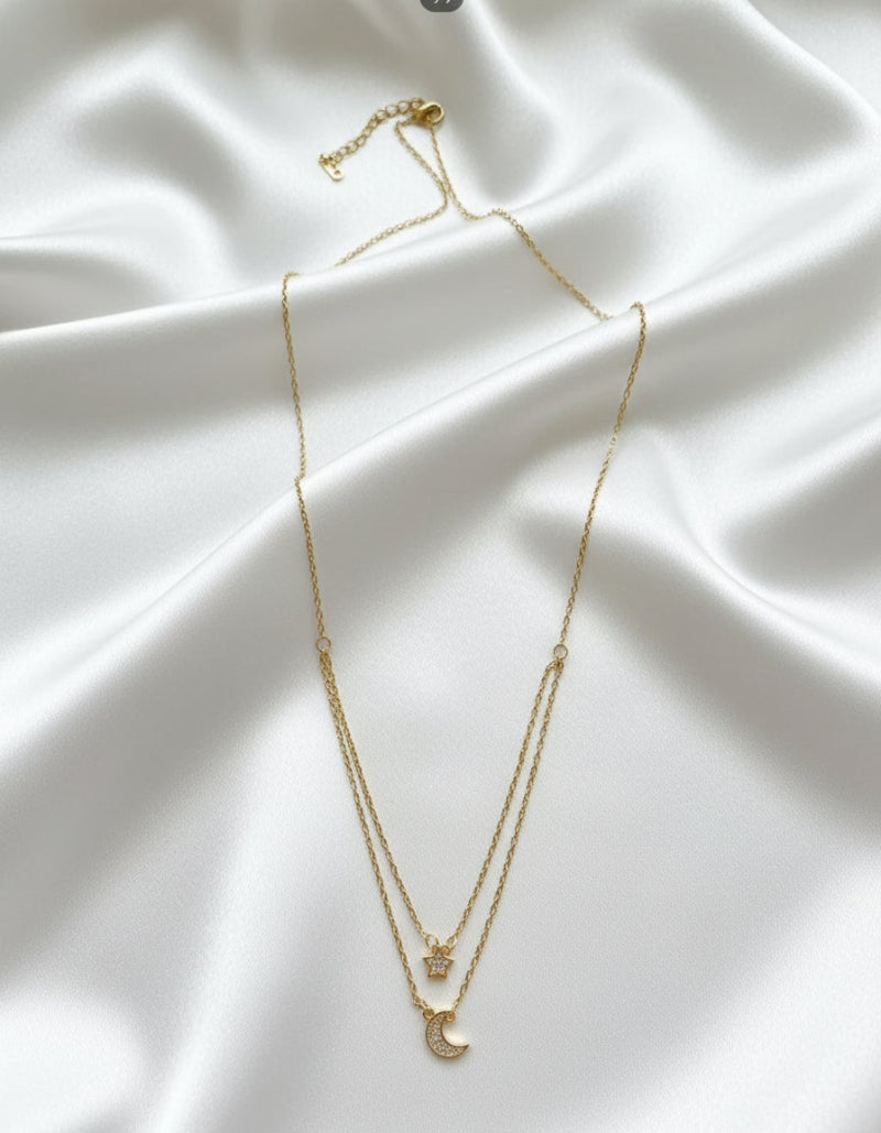 Gold necklace with a crescent moon pendant on a white background