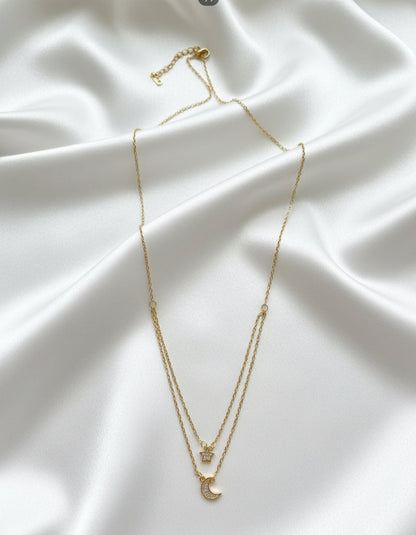 Gold necklace with a crescent moon pendant on a white background