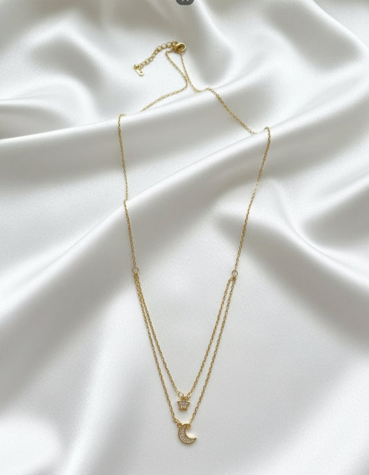 Gold necklace with a crescent moon pendant on a white background