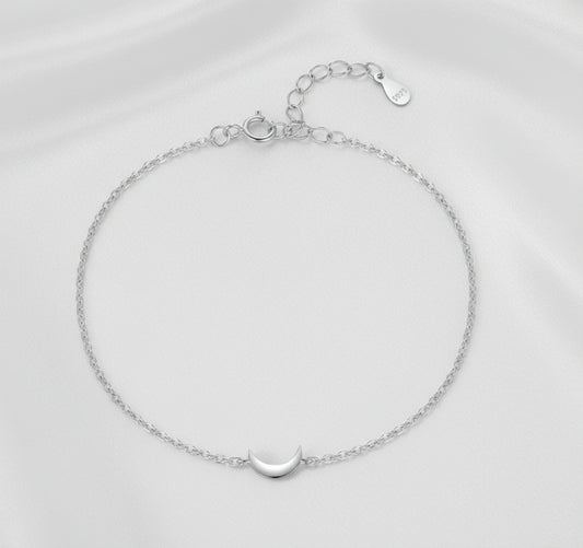 Silver bracelet with a moon charm on a white background