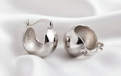 Pair of silver hoop earrings on a white background