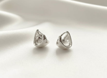Pair of silver teardrop-shaped earrings on a white background