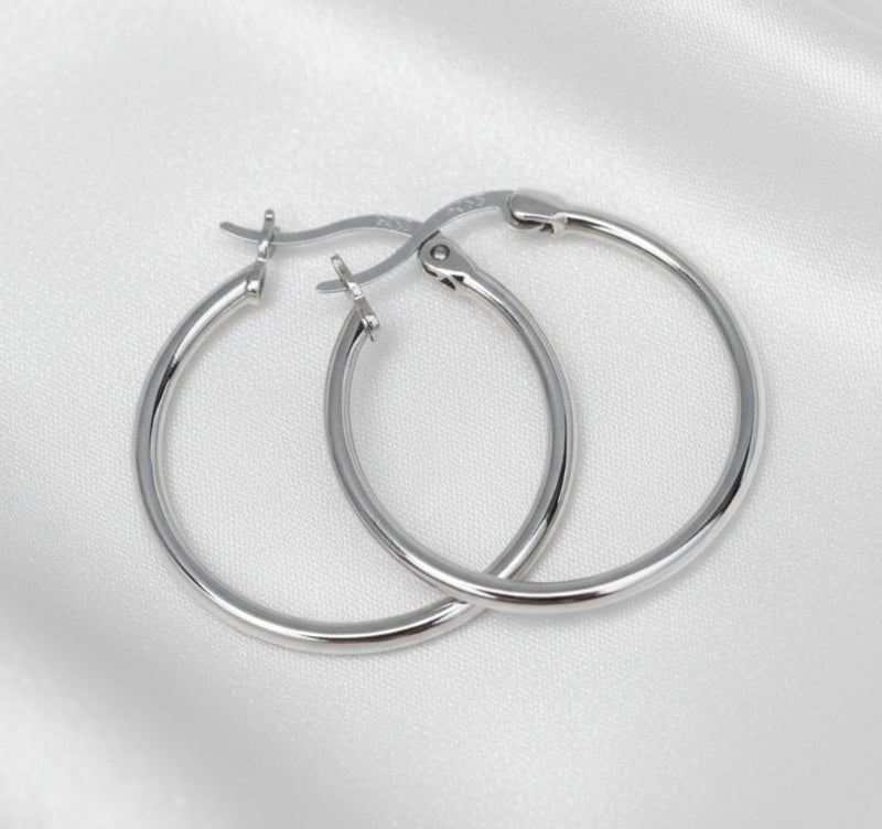 Pair of silver hoop earrings on a light gray background