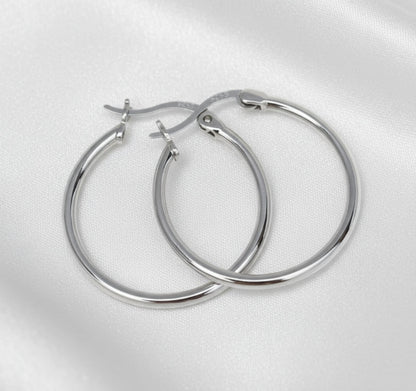 Pair of silver hoop earrings on a light gray background