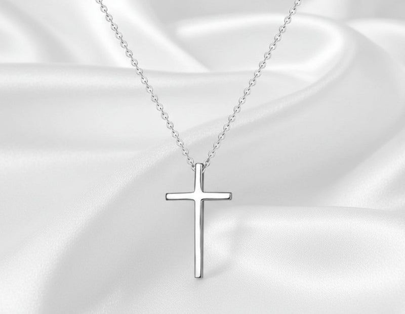 Silver cross necklace on a white background